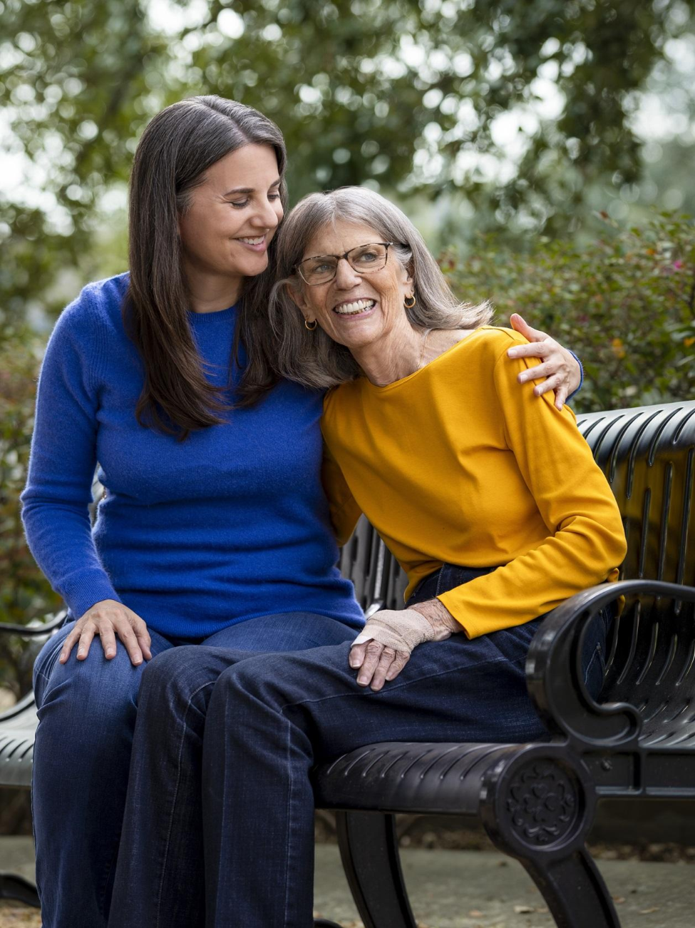 A mother and daughter sitting together on a bench