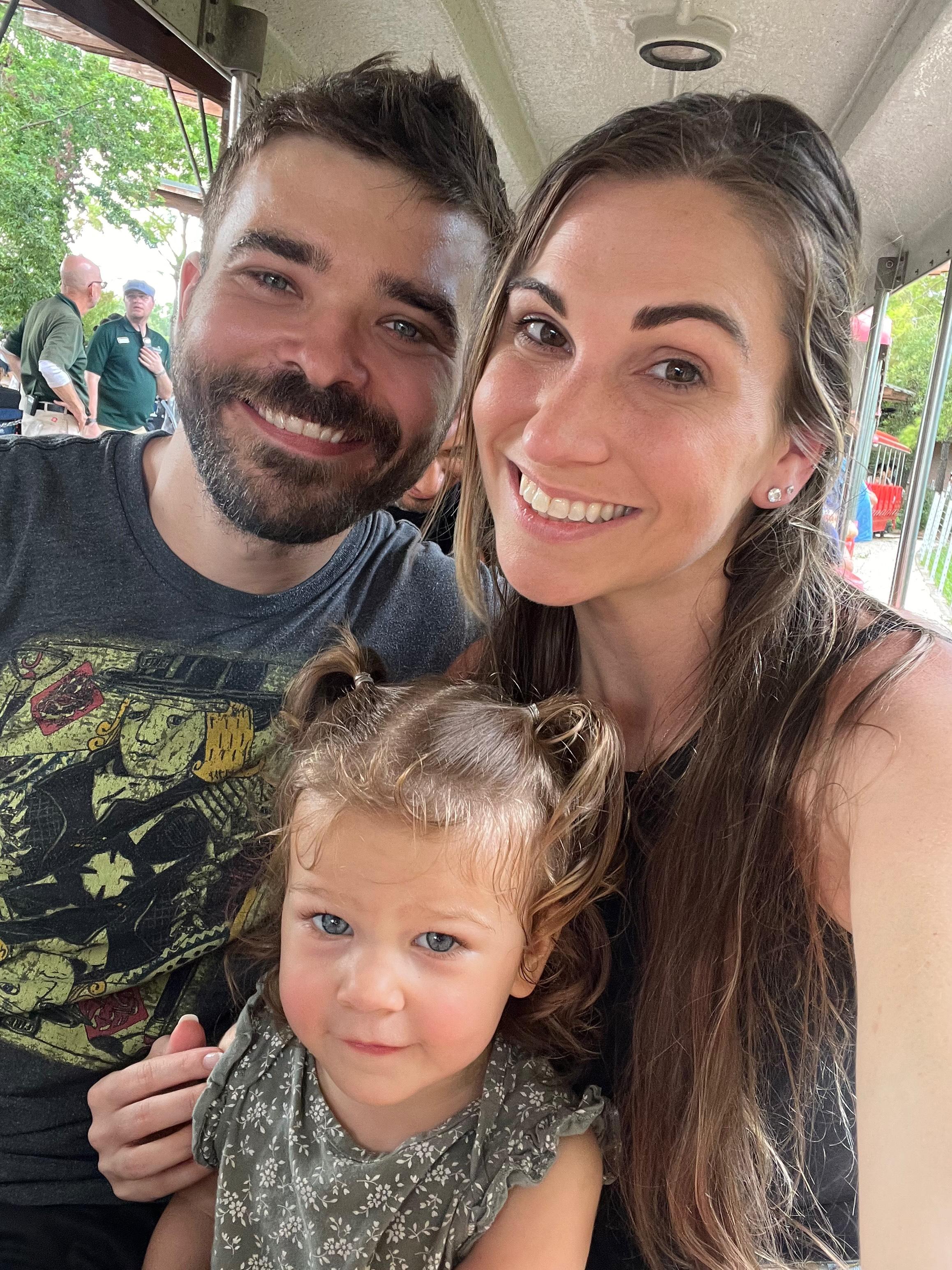 Photo of Luke with his wife and daughter.