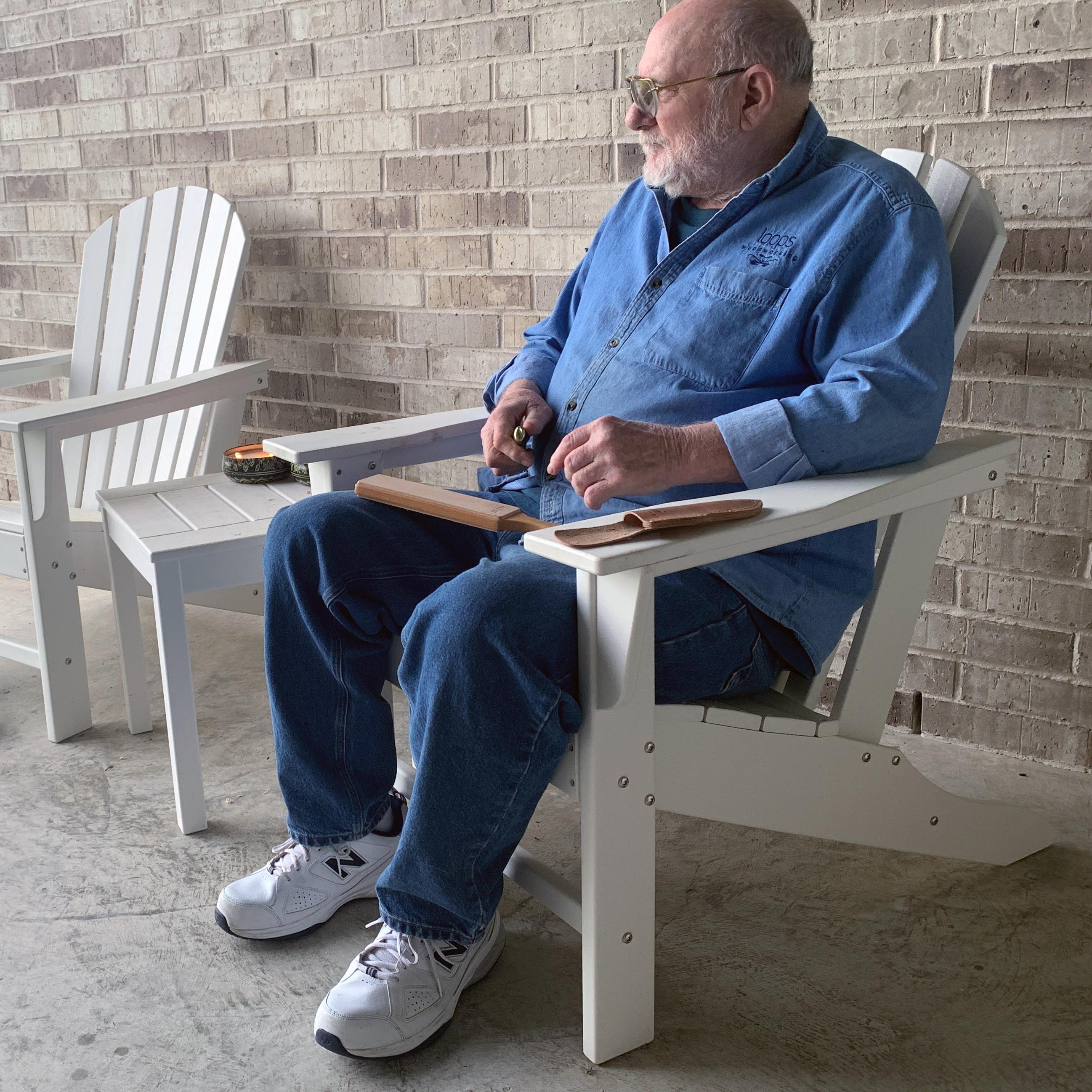 Myron on his porch carving a spoon